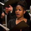 Choir singer holding musical score performing in a concert wearing black top