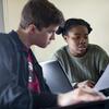 Two students read a paper together.