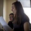 Student reading out loud from a paper in a classroom. 