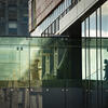A student walks across the glass bridge between buildings on Temple's main campus.
