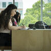 Three students studying at a table in the library