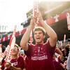 Temple students wearing university T shirts and waving banners that say 'Owls'